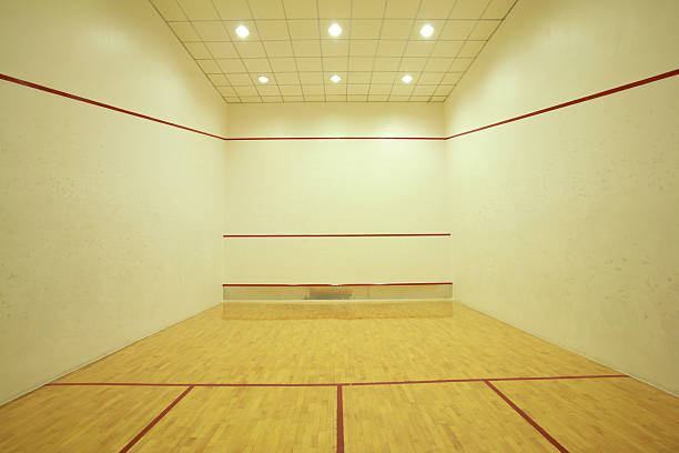 Traditional squash court with wooden floor and beige walls