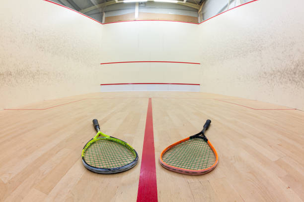 Squash court with colorful rackets on wooden floor